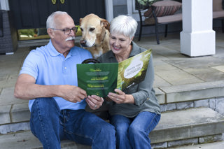 homeowners and their dogs look at folder