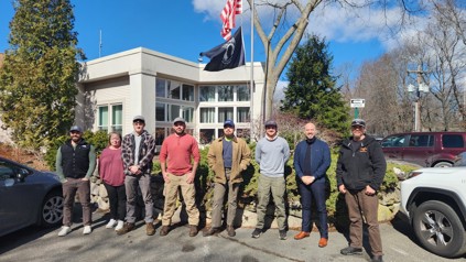 A group of workers standing in front of a building.