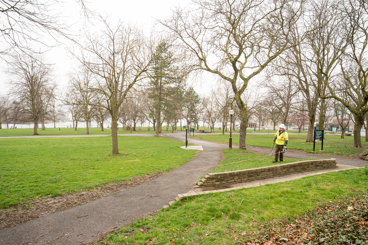 A gloomy-weathered park with leafless trees lining the pathways.