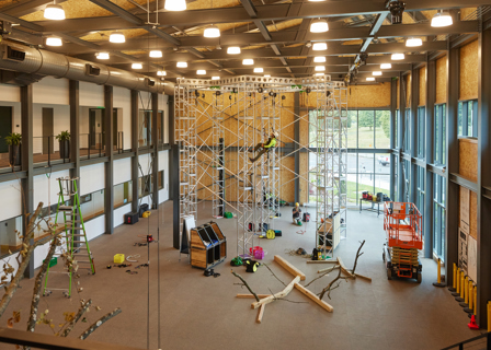 Inside Davey's climbing center with a climber on the structure