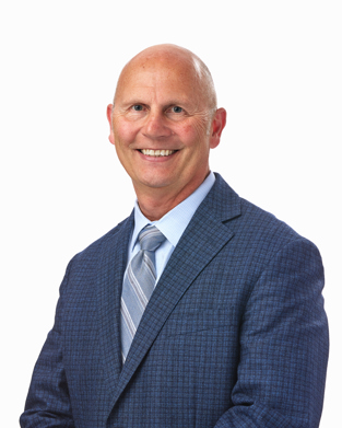 A professional headshot of a man in a suit against a white background