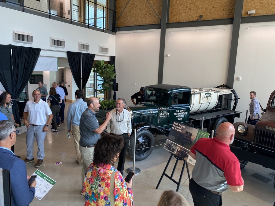 Dan Joy talks with guests near restored vehicles in SEED Campus lobby.