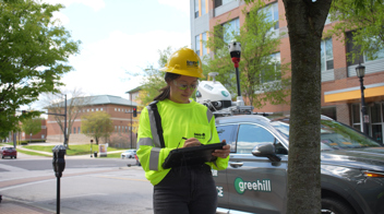 greehill employee surveying a tree with greehill car in background