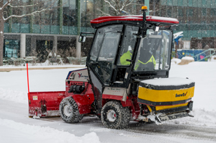 red truck removes snow for a path