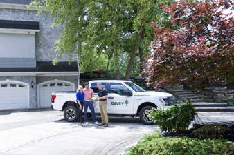 arborists talking with clients in front of davey truck