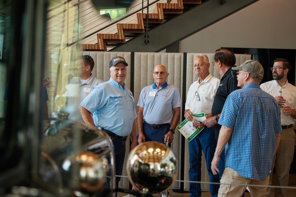 Employees and retirees admire artifacts in lobby