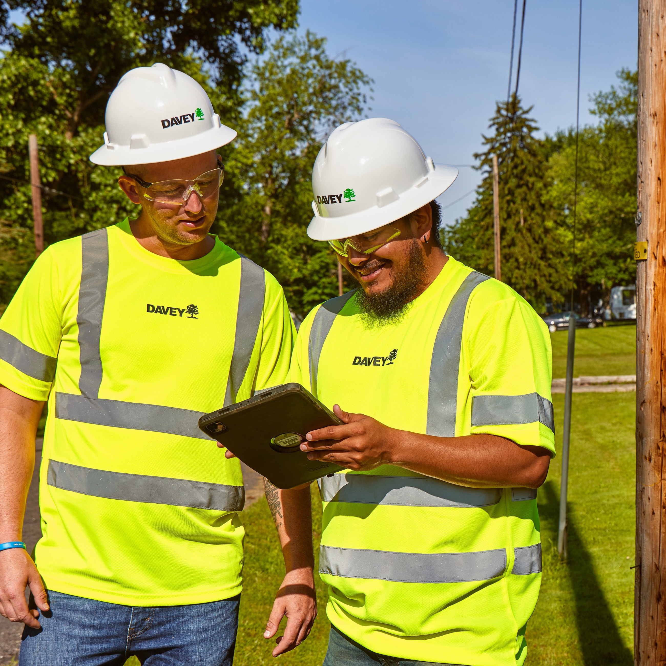 Field Crew Of Two PPE Looking At Ipad CROPPED