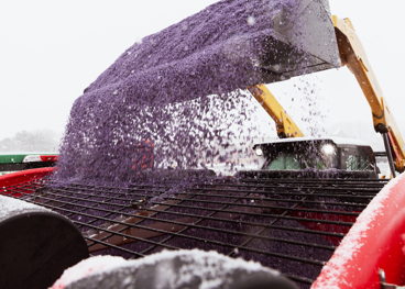 A large truck dumping rock salt