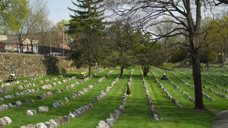 A cemetery being maintained by a crew.