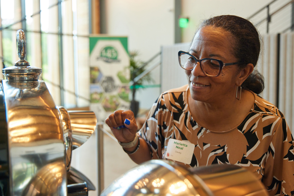 Employees and retirees admire artifacts in lobby